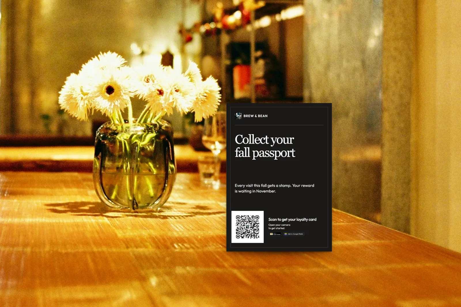 Illustration: an A6 "Collect your fall passport" loyalty card sign with a QR code on a café table