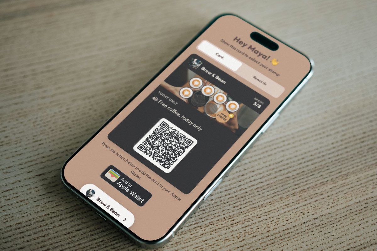 Illustration: an iPhone lying face up on a light oak table, showing a Brew & Bean loyalty card page at 5 of 8 brews with the campaign header TODAY ONLY and the line Free coffee, today only