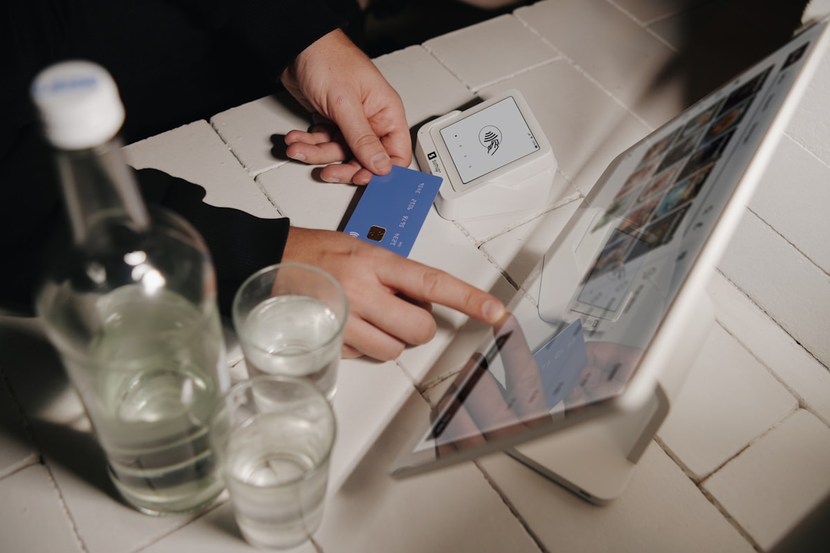 Customer paying with a contactless card at a cafe counter with a tablet POS system