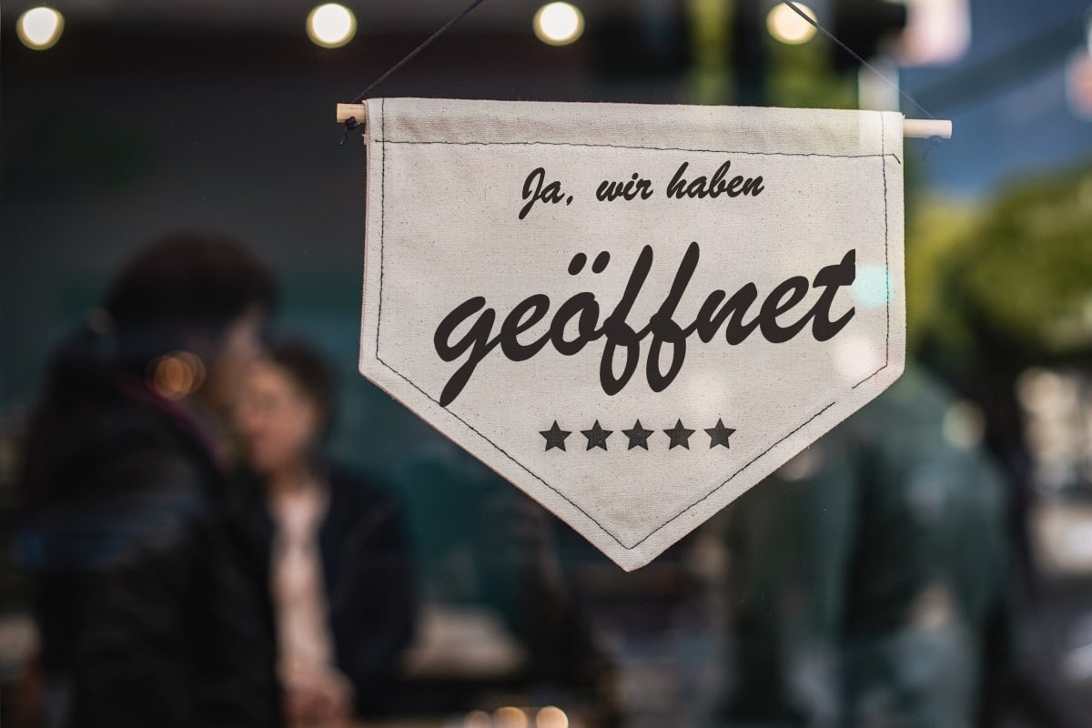 Geöffnet-Schild im Schaufenster eines kleinen Geschäfts