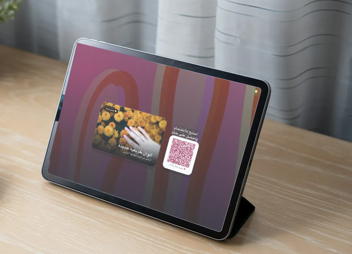 رسم توضيحي: جهاز iPad على مكتب خشبي فاتح يعرض عرضاً لصالون أظافر بعنوان "New autumn shades" ورمز QR للانضمام والحصول على ختم.