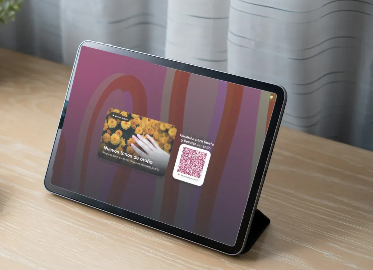 Ilustración: un iPad sobre un escritorio de madera clara con una promoción de un salón de uñas, "New autumn shades", y un código QR para unirse y conseguir un sello.